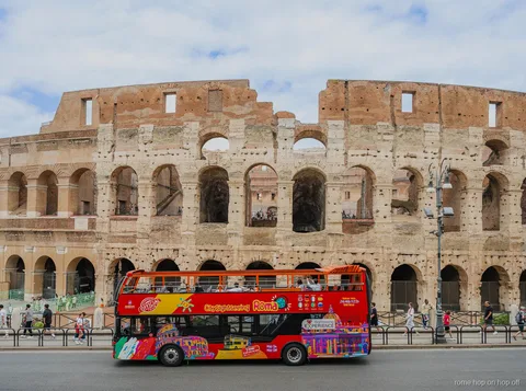 Bus turístico de Roma City Sightseeing en su vuelta descubierta cerca del Coliseo