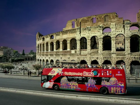 Bus hop-on hop-off Rome de nuit passant devant le Colisée illuminé